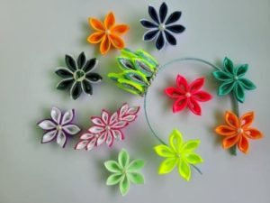 Bunte Kanzashi-Blumen aus gefalteten Satinbändern als Beispiel für das Kreativangebot der Familienfreizeit.